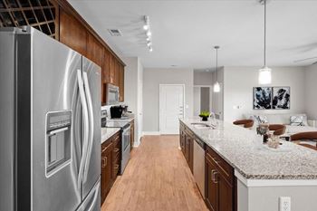 A modern kitchen with a stainless steel refrigerator and wooden cabinets.